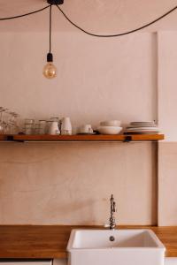 a kitchen with a sink and a shelf with dishes at Surfescape Fuerteventura in Lajares