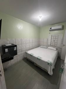 a small bedroom with a bed and a television at Elite Hotel 02 in Teresina