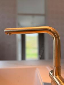 a bronze kitchen faucet of a sink at Renoviertes Haus am Sommerdeich in Freiburg - Elbe
