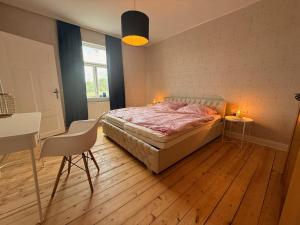 a bedroom with a bed and a table and chairs at Renoviertes Haus am Sommerdeich in Freiburg - Elbe
