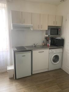 Studio 20 m2-Proche gare في لا روش سور يون: مطبخ مع حوض وغسالة ملابس