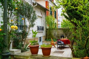 eine Außenterrasse mit Pflanzen, einem Tisch und Stühlen in der Unterkunft Cosy New Studio 2 min RER B in Aulnay-sous-Bois + 5 Fotos