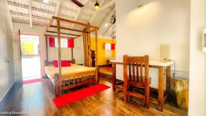 a room with a bunk bed and a desk and a table at Arabica Homestay in Somvārpet