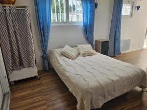 a bedroom with a bed with blue drapes at logement cocooning in Ardenais