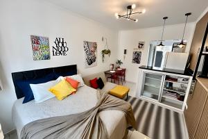 a bedroom with a bed with colorful pillows at SHB - Studio in the Heart of Gonzaga by the Sea in Santos