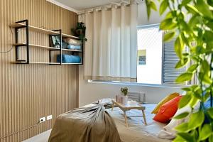 a room with a bed with a table and a window at SHB - Studio in the Heart of Gonzaga by the Sea in Santos