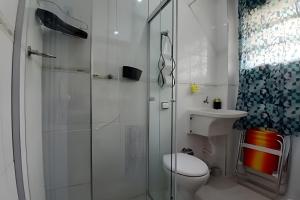 a bathroom with a toilet and a glass shower at SHB - Studio in the Heart of Gonzaga by the Sea in Santos +26 photos