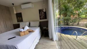 a bedroom with a bed and a swimming pool at Villas do Pratagy-Tulipa 1101 in Maceió +31 photos