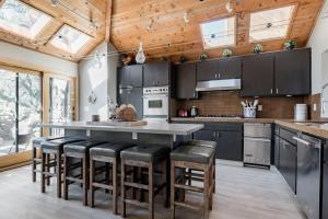 a kitchen with black cabinets and bar stools at Relax and Rejuvenate- Lafayette Treehouse with Cave Spa, Waterfall, and Incredible Views in Lafayette
