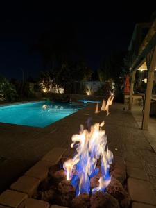 a fire pit in front of a swimming pool at night at OC Heated Pool,Fire Pit,Spa,BBQ,Disney,Beaches in Mission Viejo