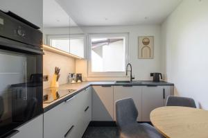 a kitchen with a sink and a table and a window at Premium Apartament Boya 44 in Zgierz