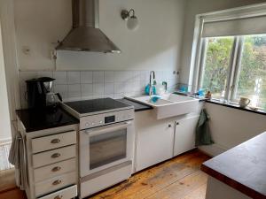 una cocina con fregadero y estufa horno superior en Mysigt stenhus i Simrishamn, en Simrishamn 10 fotos más