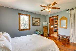 a bedroom with a white bed and a ceiling fan at Walk to River Couples Retreat in Kintnersville! in Kintnersville