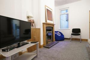 a living room with a large flat screen tv at Close to Belfast City Centre Townhouse in Belfast