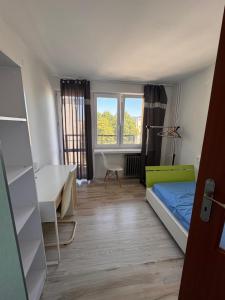 a room with a bed and a desk and a table at Majeczka in Biała Podlaska