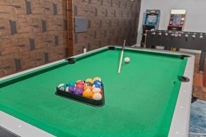 a pool table with a ball and a cue at Coffee Themed - Cozy Family Getaway - Sleeps 12 - Mini Golf BBQ Yard in Westminster