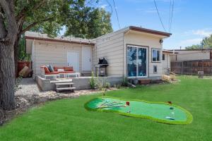 a backyard with a miniature golf course in the grass at Coffee Themed - Cozy Family Getaway - Sleeps 12 - Mini Golf BBQ Yard in Westminster