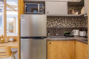 a kitchen with a stainless steel refrigerator and a sink at My Savvas Studios in Haraki