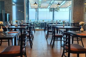 a restaurant with tables and chairs and a large window at Wyndham Garden Antofagasta Pettra in Antofagasta