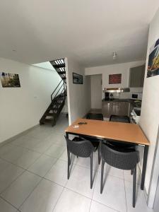 een keuken en eetkamer met een tafel en stoelen bij Maison de campagne proche D'Angers in La Meignanne