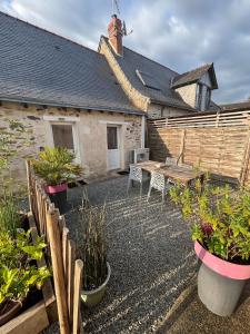 een tuin met een houten tafel en potplanten bij Maison de campagne proche D'Angers in La Meignanne