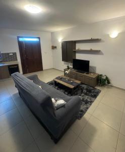 un soggiorno con un divano e una TV di Room Cozy in San Julian 2 a San Giuliano