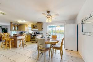 Una cocina con una mesa y un refrigerador blanco. en Snook Heaven, en Punta Gorda