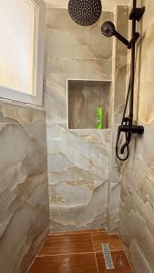 a shower with a stone wall in a bathroom at Hostel Chilli in Tirana