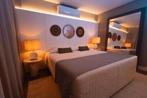 拉热斯勒卡纳德拉各斯酒店的带一张大床和一面镜子的卧室