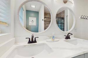 Baño blanco con 2 lavabos y 2 espejos en Manatee Bungalow, en Bradenton 12 fotos más