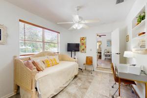 sala de estar con sofá blanco y escritorio en Manatee Bungalow, en Bradenton