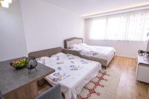 a small room with two beds and a table and a table sidx sidx at Apartmani IMPERIAL in Novi Pazar