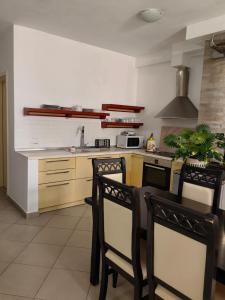 y cocina con mesa, sillas y fogones. en Leka Guest house, en Pogradec