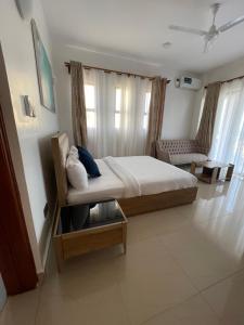 a bedroom with a bed and a chair in it at Two bedroom Villa in Mombasa +30 photos