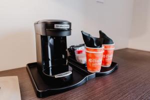 a coffee maker with shoes and coffee cups on a table at Comfort Inn & Suites Tobago in Tobago Island