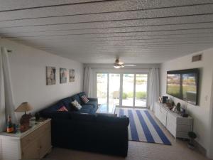 a living room with a blue couch and a tv at 111 Ground Floor Beach Sunset Cove - sunset views in George Town