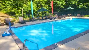 a large blue swimming pool with chairs and umbrellas at Beautiful Escape by American Patriot Getaways in Cove Creek Cascades