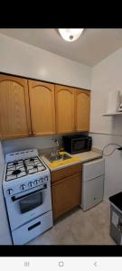 una cucina con stufa bianca e armadietti in legno di APARTAMENTO EN ATLANTIS VISTA UNICA PISCINA JACUZZIi ad Armenia