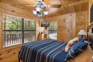 a bedroom with a bed in a log cabin at Beautiful Escape by American Patriot Getaways in Cove Creek Cascades +30 photos