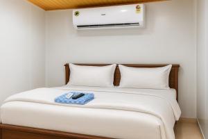 een bed met een afstandsbediening erop bij Heaven Stay Resort in Shankerpalli +13 foto's