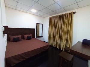 a bedroom with a large bed and a window at Dhunhill Garden in Avissawella +6 photos