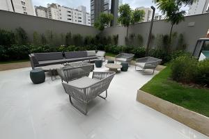 Un patio con mesas y sillas y un banco. en Estúdio de Luxo Florança, en São Paulo