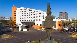 a statue in the middle of a street with a building at Real Inn Tijuana by Camino Real Hoteles in Tijuana