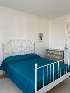 a bedroom with a bed with a blue blanket and a dresser at Casa CuOr in Senigallia