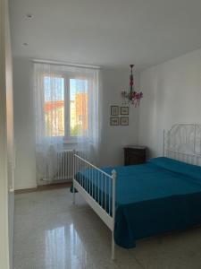 a bedroom with a blue bed and a window at Casa CuOr in Senigallia