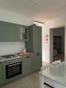 a kitchen with green cabinets and a stove top oven at Casa CuOr in Senigallia