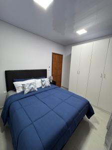 a bedroom with a blue bed and white cabinets at Ap Centro in Ciudad del Este