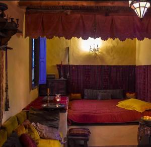 a living room with a red bed and a couch at Dar Tiziri in Sousse