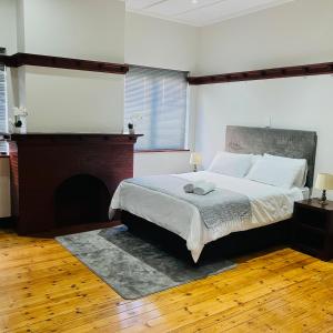 GqeberhaにあるPeaceful Home In Richmond Hillの大きなベッドと暖炉のある寝室