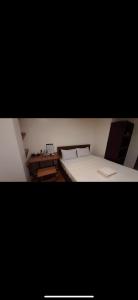 a bedroom with a white bed and a desk at A Place To Remember Inn in El Nido +1 photo